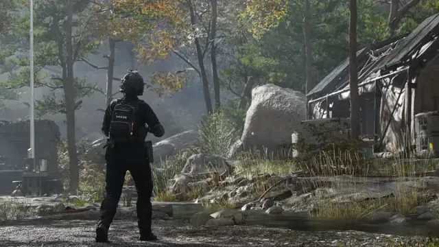 An operator walking toward a forward operating base camp in a forest clearing