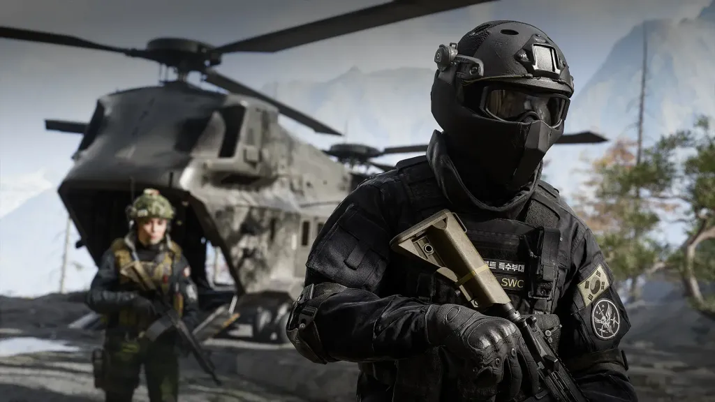 Operators in helmets and packs standing beside a helicopter on the ground